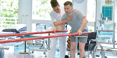 Physical therapist helping a resident with walking therapy.